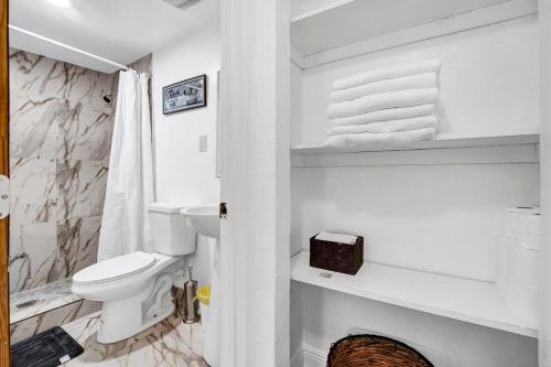 a white bathroom with a toilet and a sink at Miami stays vacations in Miami