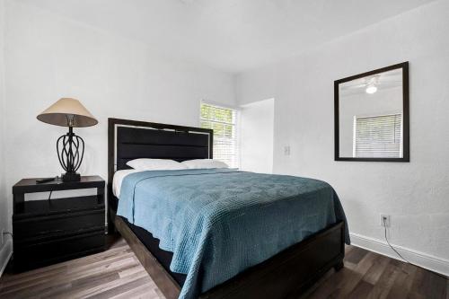 マイアミにあるMiami stays vacationsのベッドルーム(ベッド1台、ランプ、鏡付)