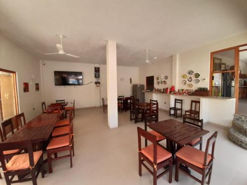 una sala da pranzo con tavoli e sedie in legno di Habitaciones en Vichayito a Vichayito