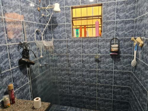 a bathroom with a shower with blue tiles at Casa para Temporada Agrishow 2024 in Ribeirão Preto