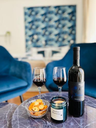 a bottle of wine and two glasses on a table at Marcel Zadar Old Town in Zadar