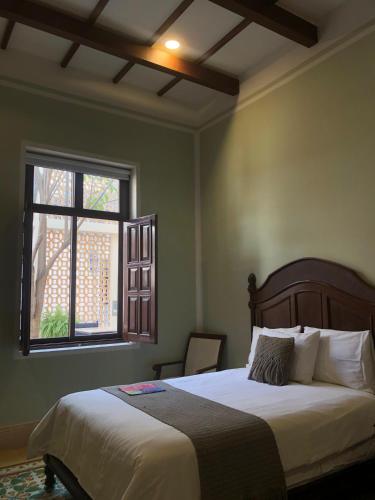 a bedroom with a large bed and a window at Casa Tavera- Adults Only in Mérida
