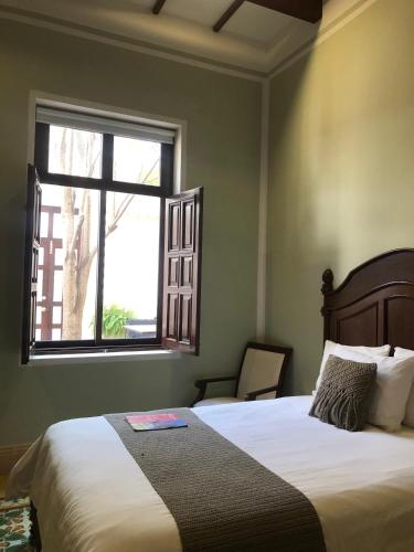a bedroom with a large bed with a window at Casa Tavera- Adults Only in Mérida