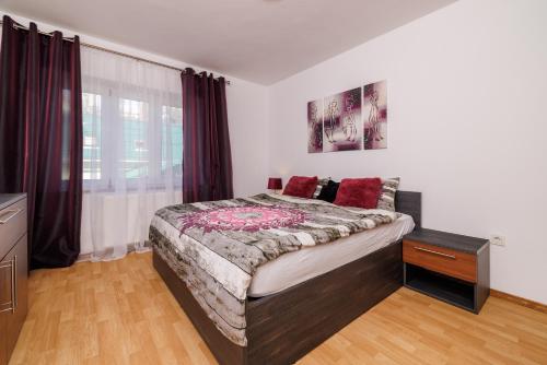 a bedroom with a large bed with red pillows at Apartmani Anđelić- Fužine 1 in Fužine