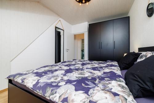 a bedroom with a bed with a purple comforter at Apartmani Anđelić- Fužine 1 in Fužine