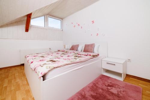 a white bedroom with a bed and a window at Apartmani Anđelić- Fužine 1 in Fužine