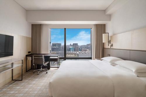 a hotel room with a bed and a desk and a computer at Taipei Marriott Hotel in Taipei