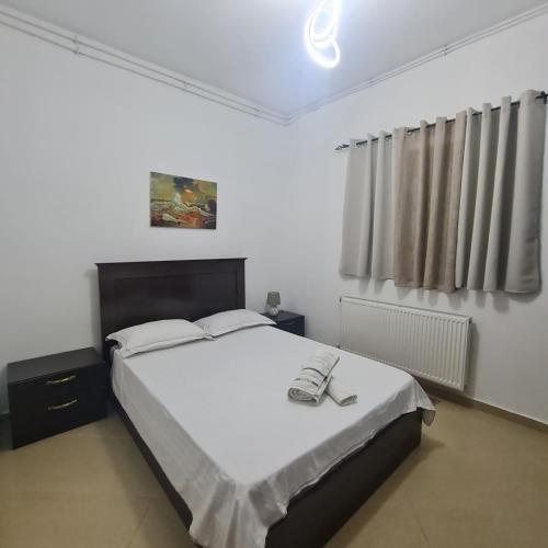 um quarto com uma cama com um telefone em Villa Llanaj em Berat