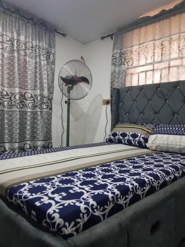 a bedroom with a bed with a fan and curtains at A Cosy Room and a Parlor-Self in Ikeja