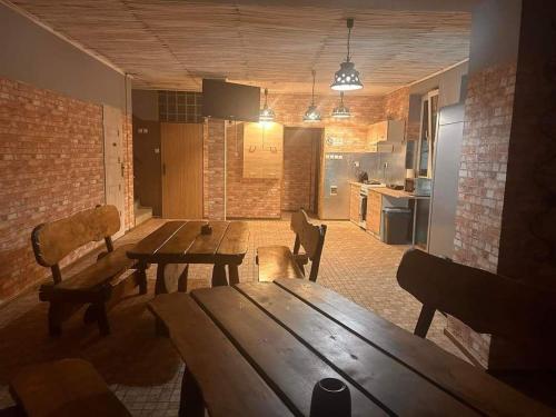 Habitación con mesa de madera, sillas y cocina. en POKOJE HOTELOWE VIKTORIA, en Słupno