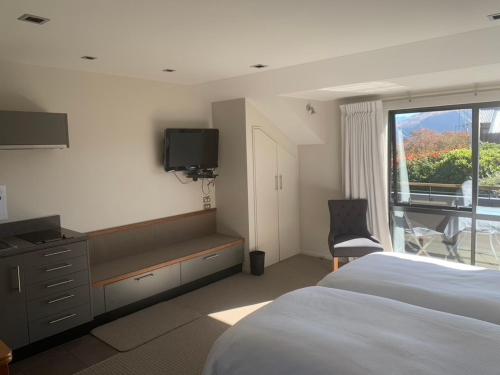 una camera da letto con un letto, una tv e una finestra di Aspiringlofts a Wanaka