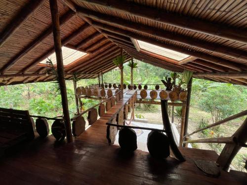 einen Pavillon mit Holzboden und einem langen Tisch in der Unterkunft Wisdom Forest Lodge in Tena