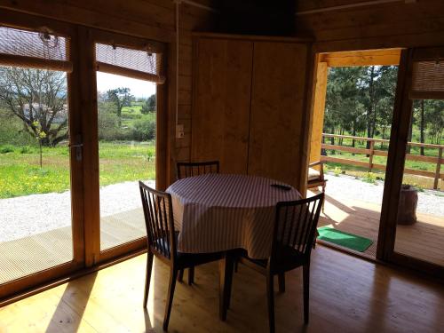 a table and chairs in a room with a porch at Quinta dos Mangues in São Martinho do Porto
