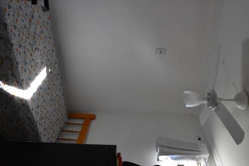 a room with a ceiling fan and a window at Hostel Cascavel in Cascavel