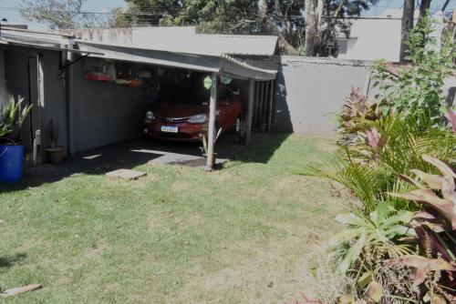 a car is parked in a garage at Hostel Cascavel in Cascavel