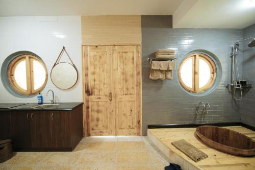 uma casa de banho com uma banheira de madeira e 2 espelhos em Quảng Ninh Gate Hotel & Resort em Bác Mã