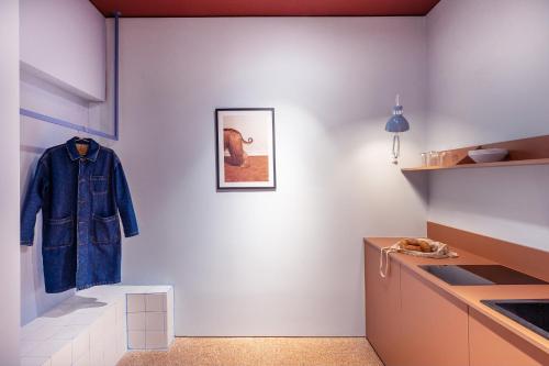 un manteau bleu accroché au mur dans une cuisine dans l'établissement Acre Urban Studios in Monastiraki, à Athènes