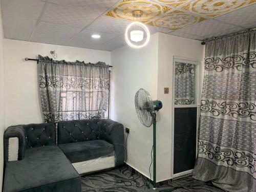 a living room with a couch and a fan at A Cosy Room and a Parlor-Self in Ikeja