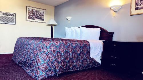 una habitación de hotel con una cama con una manta colorida en Travelors Lodge Motel & RV Park US-287&US-96, en Eads