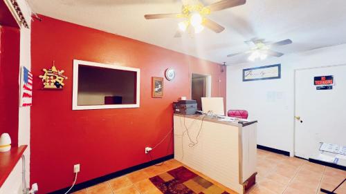 sala de estar con pared roja y TV en Travelors Lodge Motel & RV Park US-287&US-96, en Eads