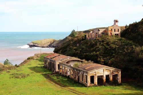 an old train on a hill next to the ocean at Hotel Villanueva San Jorge de Heres in Villanueva