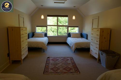 1 dormitorio con 2 camas individuales y ventana en SookeDreams, en Sooke