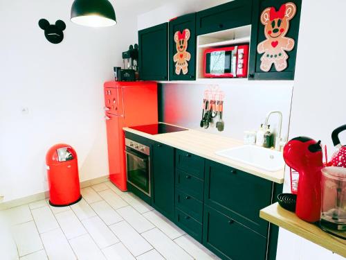 a kitchen with green cabinets and a red refrigerator at Appartement de Mickey à 5 min de Disneyland Paris in Serris