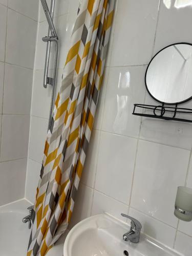 a bathroom with a sink and a mirror at Amazing Ground Floor one bedroom apartment Forest Road in London