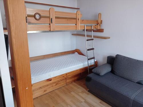 a bunk bed with a ladder next to a couch at Gdańsk Mieszkanie parter Marine in Gdańsk