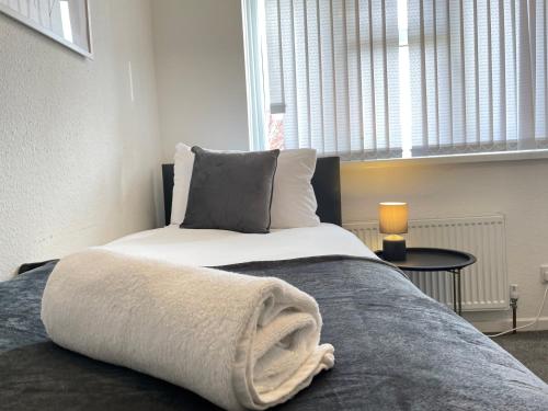 a bedroom with a bed with a towel on it at Long Stays in Birmingham - 1 Bedrooms, 1 Baths, 2 Separate Beds & Parking in Birmingham