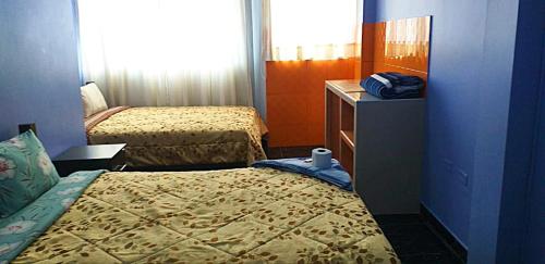 um pequeno quarto com 2 camas e uma cómoda em PAKKARIN - HOTEL em Chachapoyas