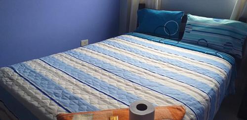 1 cama con edredón de rayas azul y blanco en PAKKARIN - HOTEL, en Chachapoyas