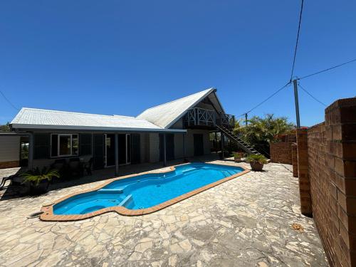 a swimming pool in front of a house at Bas de villa Noumea in Noumea