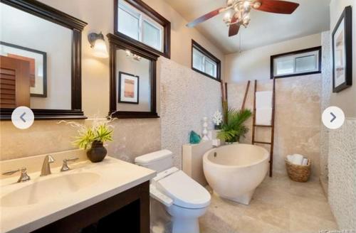 a bathroom with a tub and a toilet and a sink at Tropical Paradise…pristine sandy beaches and clear blue water in Waimanalo