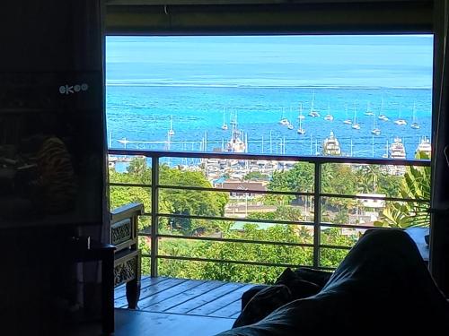 a room with a view of the ocean and boats at MARINA BLUE fabuleux Appartement vue LAGON in Punaauia