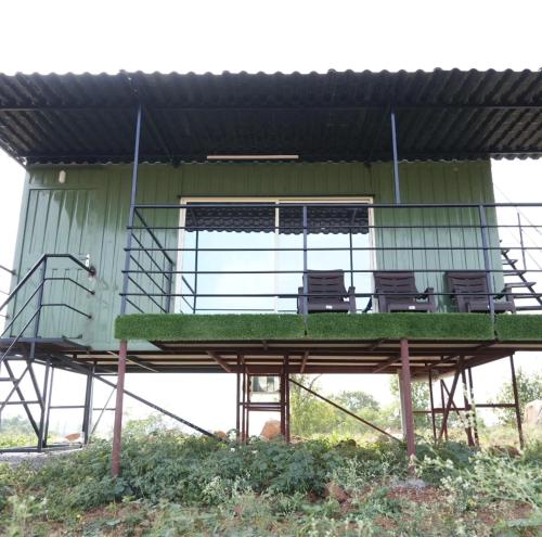 un edificio con una terraza con sillas. en Birds of paradise foundation, en Bangalore