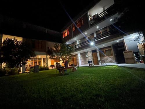 a building with a lawn in front of it at night at La Fogata del Sur in Fundo Copacabana