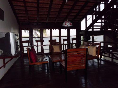 a dining room with a table and chairs and a tv at WOODEN CHALET ON THE RIVER BANKS in Old Goa