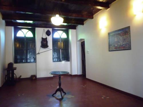 a room with a table in a room with windows at WOODEN CHALET ON THE RIVER BANKS in Old Goa