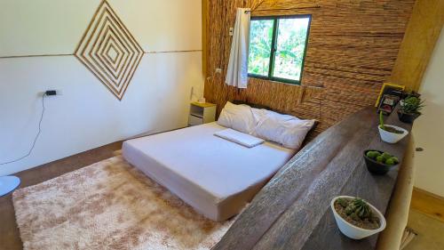 a room with a bed and a wooden table at Tropical Haven with Dedicated Office Space in Siargao in General Luna