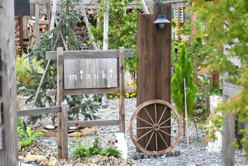 a garden with a wooden fence and a wooden wheel at mizuki - Vacation STAY 12130v in Higashikawa