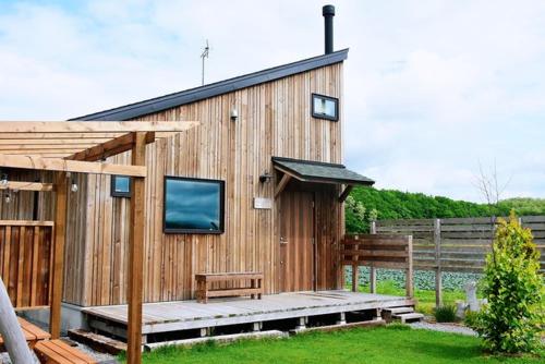 a wooden building with a bench and a tv on it at mizuki - Vacation STAY 12130v in Higashikawa