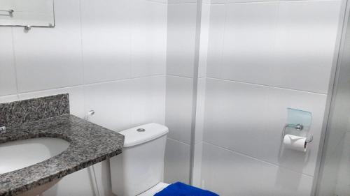 a bathroom with a toilet and a sink and a shower at Jockey Family_Suave in Vila Velha