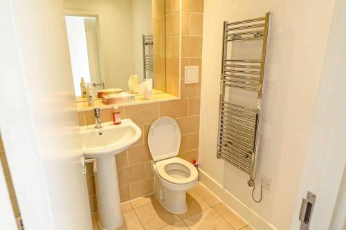 a bathroom with a toilet and a sink at 2bed Central Apartment + Gym + Pool in London