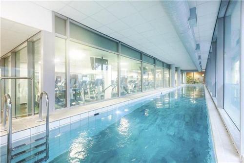 a swimming pool with blue water in a building at 2bed Central Apartment + Gym + Pool in London