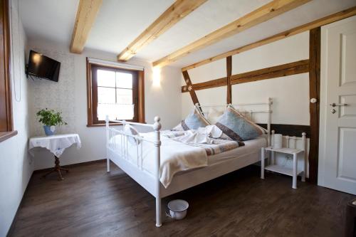 ein Schlafzimmer mit einem weißen Bett und einem Fenster in der Unterkunft Pension Alte Schmiede in Zabeltitz