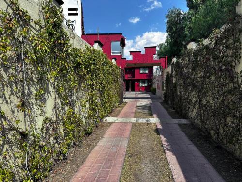 une allée en briques avec un bâtiment rouge en arrière-plan dans l'établissement Paléis, à Santa Cruz Tecamac