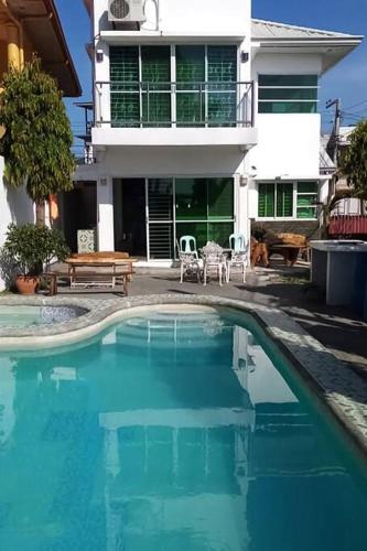 a swimming pool in front of a house at White House near Thunderbird Resort in Parian