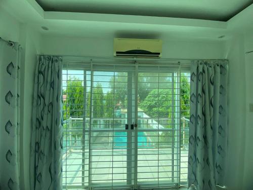 a room with a large window with curtains and a balcony at White House near Thunderbird Resort in Parian