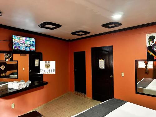 una sala de espera con paredes de color naranja y TV en Paléis en Santa Cruz Tecamac